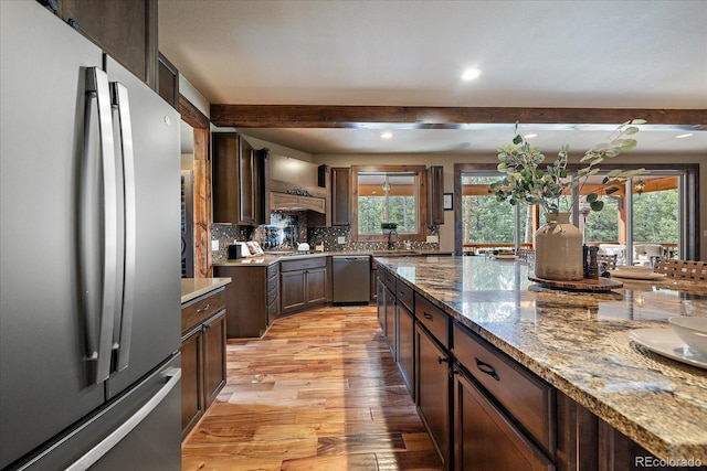 8090 S Homesteader Dr, Morrison, CO 80465 - kitchen featuring appliances with stainless steel finishes, beam ceiling, light wood-type flooring, healthy amount of natural light, and tasteful backsplash