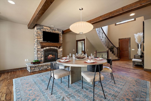 8090 S Homesteader Dr, Morrison, CO 80465 - dining space with beamed ceiling, wood finished floors, stairway, and a fireplace
