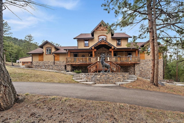 8090 S Homesteader Dr, Morrison, CO 80465 - view of front of home featuring stucco siding, stairs, stone siding, and a porch