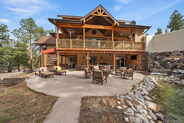 8090 S Homesteader Dr, Morrison, CO 80465 - back of house with outdoor lounge area, a patio, stucco siding, and a balcony