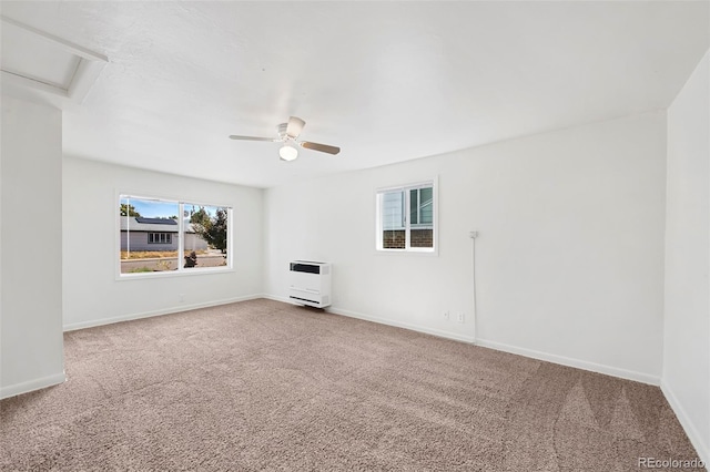 unfurnished living room featuring heating unit, ceiling fan, and carpet flooring