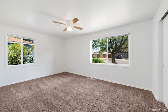 carpeted spare room with ceiling fan