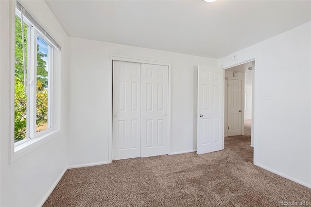 unfurnished bedroom with a closet and carpet flooring