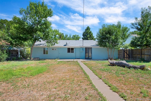 rear view of property with a lawn