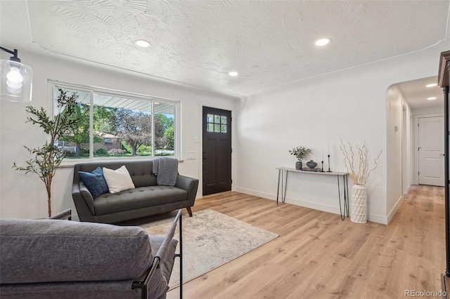6068 Lee St, Arvada, CO 80004 - living area with recessed lighting, light wood finished floors, baseboards, and arched walkways