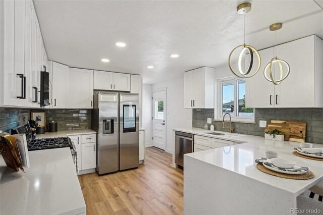 6068 Lee St, Arvada, CO 80004 - kitchen featuring stainless steel appliances, a sink, recessed lighting, light wood-style flooring, and light countertops