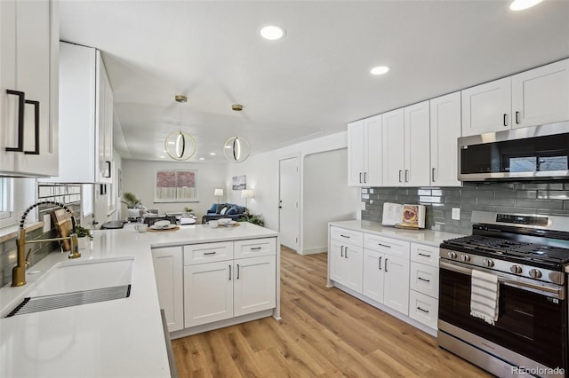 6068 Lee St, Arvada, CO 80004 - kitchen featuring stainless steel appliances, a sink, tasteful backsplash, white cabinetry, and recessed lighting