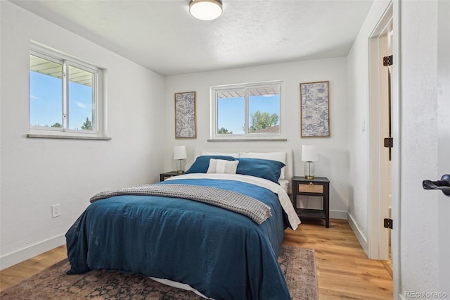 6068 Lee St, Arvada, CO 80004 - bedroom with multiple windows, wood finished floors, and baseboards
