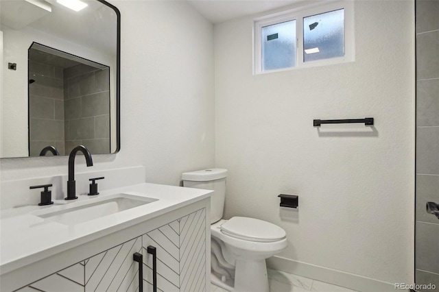 6068 Lee St, Arvada, CO 80004 - bathroom with marble look tiles, toilet, vanity, and baseboards