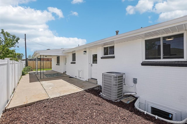 6068 Lee St, Arvada, CO 80004 - back of property with central AC, a patio, a fenced backyard, and brick siding