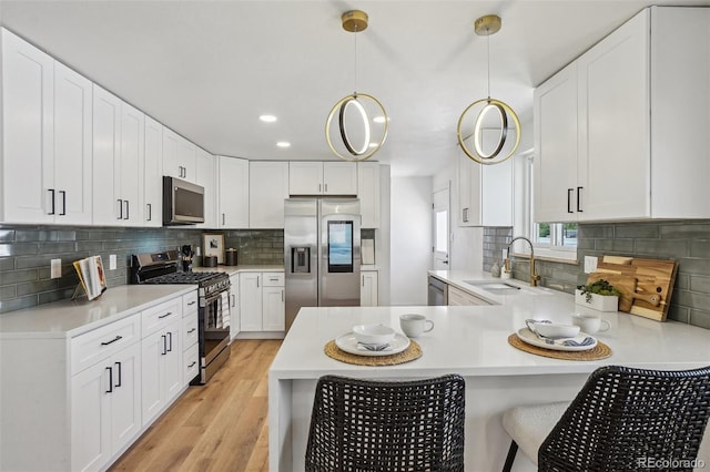 6068 Lee St, Arvada, CO 80004 - kitchen featuring stainless steel appliances, a sink, a peninsula, light countertops, and tasteful backsplash