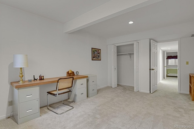 carpeted office space featuring beamed ceiling and built in desk