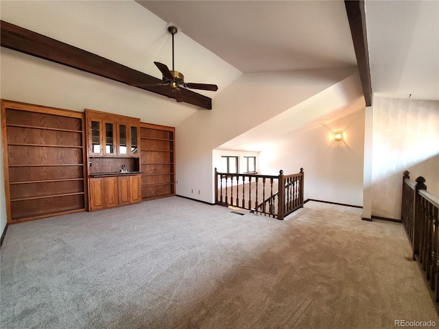 unfurnished living room with vaulted ceiling with beams and light colored carpet