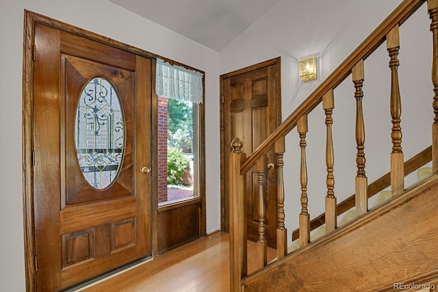 entrance foyer with plenty of natural light, vaulted ceiling, and light hardwood / wood-style flooring