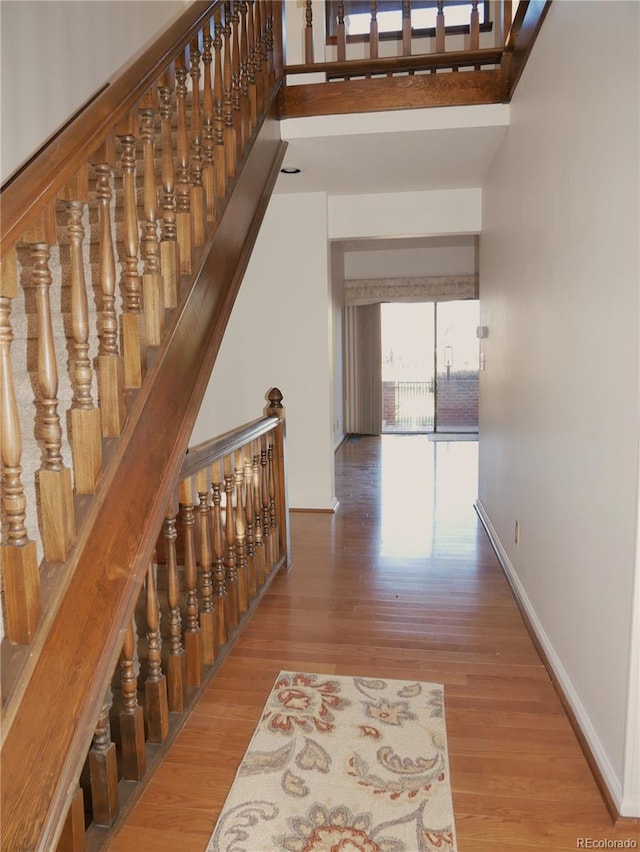 interior space featuring a towering ceiling and hardwood / wood-style flooring