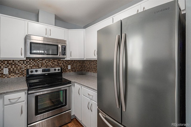 kitchen with white cabinets, stainless steel appliances, hardwood / wood-style flooring, and tasteful backsplash