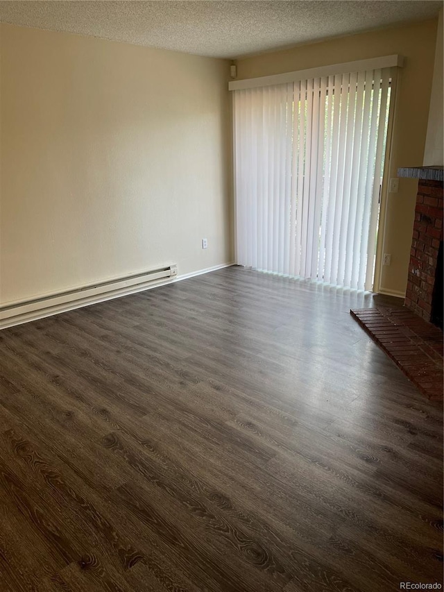 interior space featuring a fireplace, a baseboard radiator, dark wood-type flooring, and a textured ceiling