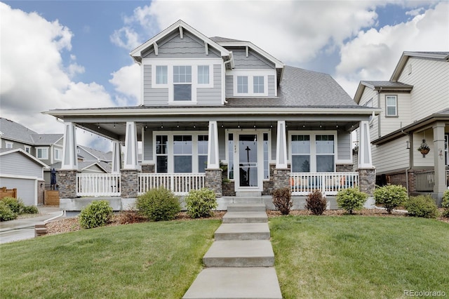 craftsman-style home with covered porch, stone siding, and a front lawn