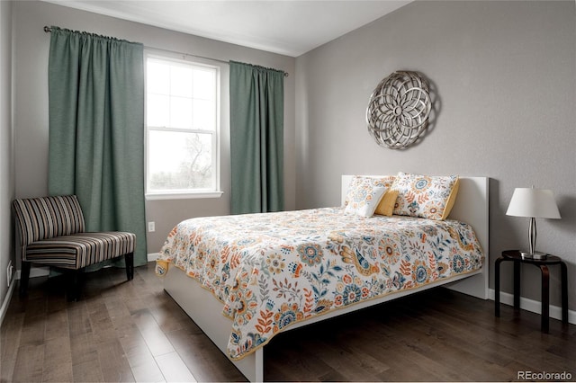bedroom with baseboards and wood finished floors