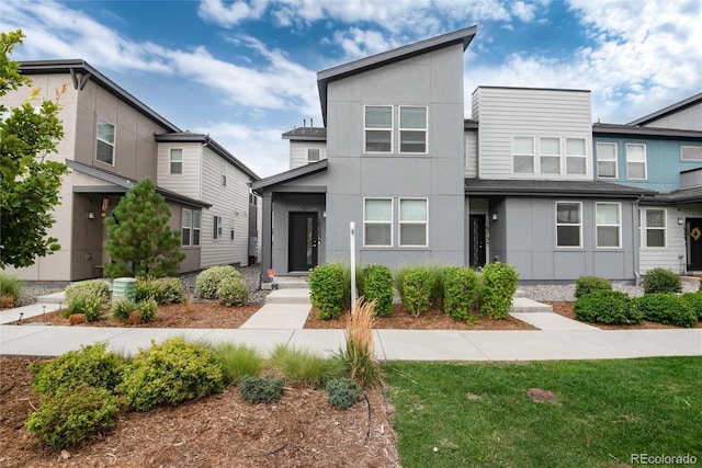 contemporary house with central AC unit and stucco siding