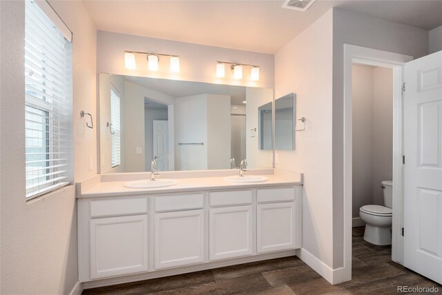 bathroom with a sink, baseboards, toilet, and wood finished floors