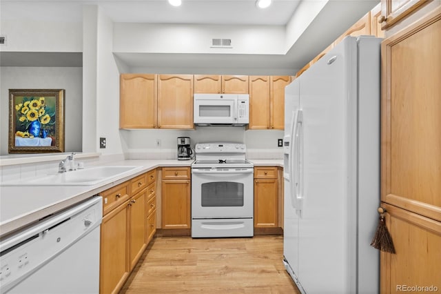 kitchen with sink, light wood-type flooring, white appliances, and light brown cabinets