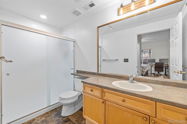 bathroom featuring vanity, toilet, and a shower with shower door