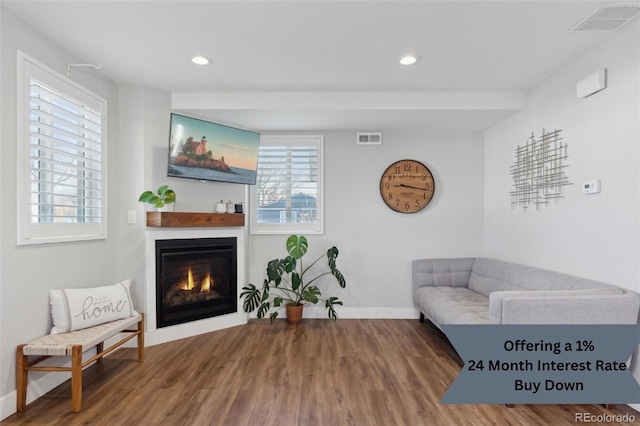 living area featuring a glass covered fireplace, baseboards, wood finished floors, and recessed lighting