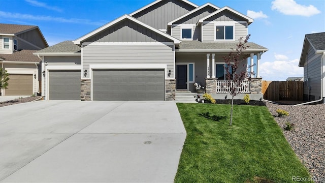 craftsman house featuring a front lawn, covered porch, and a garage