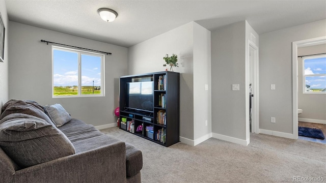 living room with a healthy amount of sunlight and light colored carpet