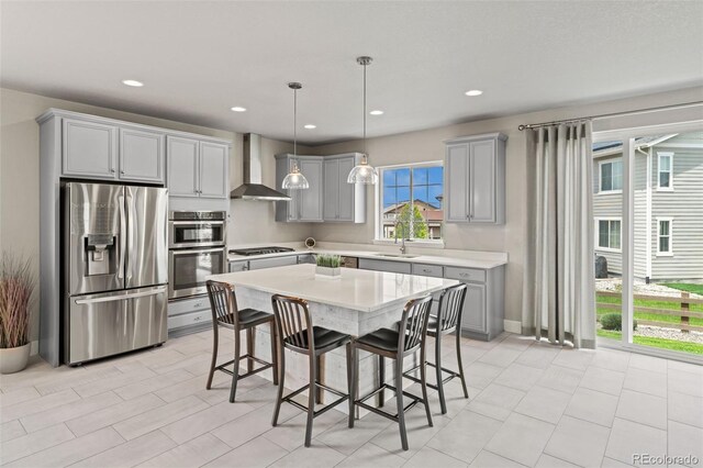 7380 S Shady Grove Way, Aurora, CO 80016 - kitchen with appliances with stainless steel finishes, gray cabinetry, wall chimney range hood, light countertops, and a kitchen bar