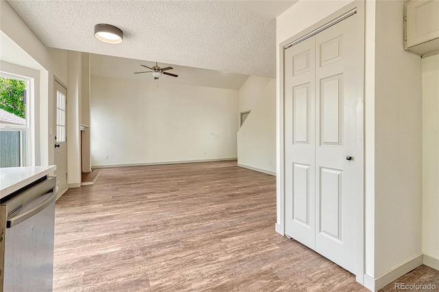 interior space with a textured ceiling, light hardwood / wood-style floors, and ceiling fan