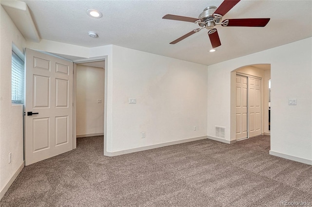 carpeted empty room featuring a textured ceiling and ceiling fan