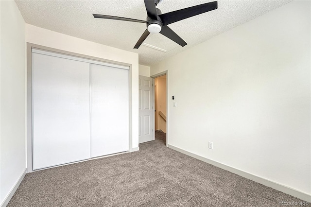 unfurnished bedroom with ceiling fan, a closet, carpet floors, and a textured ceiling