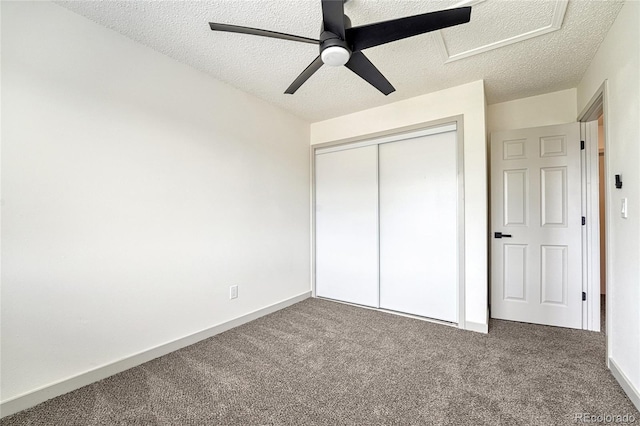 unfurnished bedroom with carpet flooring, a textured ceiling, a closet, and ceiling fan