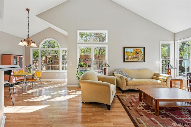 2252 S Yosemite Cir, Denver, CO 80231 - living room with an inviting chandelier, baseboards, high vaulted ceiling, and light wood-type flooring
