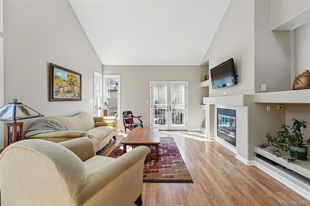 2252 S Yosemite Cir, Denver, CO 80231 - living area with baseboards, high vaulted ceiling, a glass covered fireplace, and light wood-style flooring