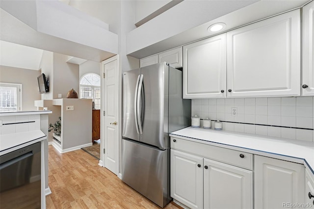 2252 S Yosemite Cir, Denver, CO 80231 - kitchen featuring light wood-style floors, appliances with stainless steel finishes, white cabinets, and light countertops