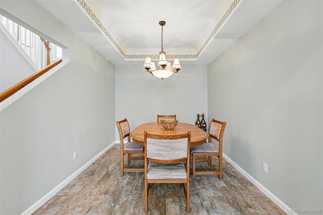 2252 S Yosemite Cir, Denver, CO 80231 - dining area with baseboards, a notable chandelier, ornamental molding, and wood finished floors