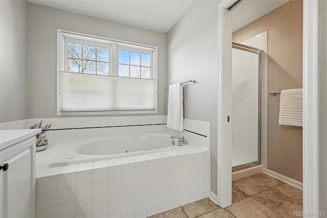 2252 S Yosemite Cir, Denver, CO 80231 - bathroom with vanity, a stall shower, a bath, and tile patterned floors