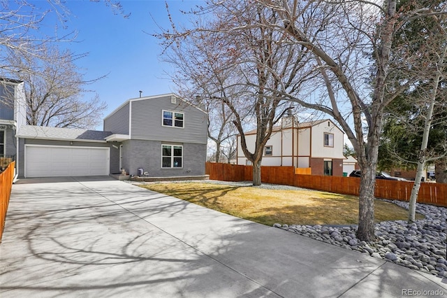 view of front of house with brick siding, a front yard, fence, a garage, and driveway