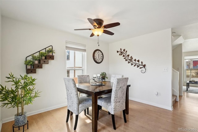 dining room featuring light wood-type flooring, ceiling fan, and baseboards