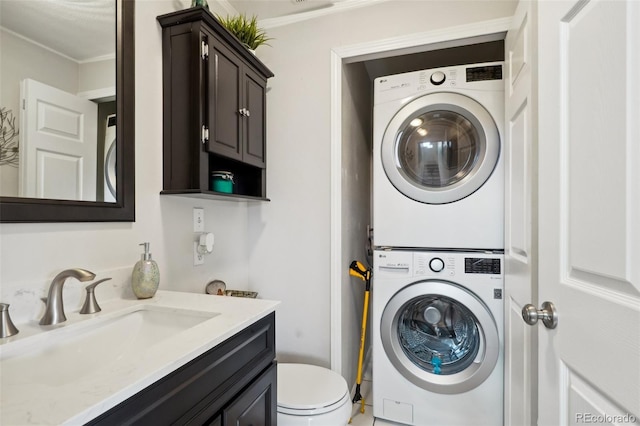 clothes washing area featuring stacked washer and dryer, a sink, and laundry area