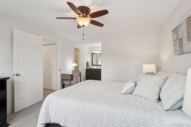 bedroom with a closet, light carpet, connected bathroom, and ceiling fan