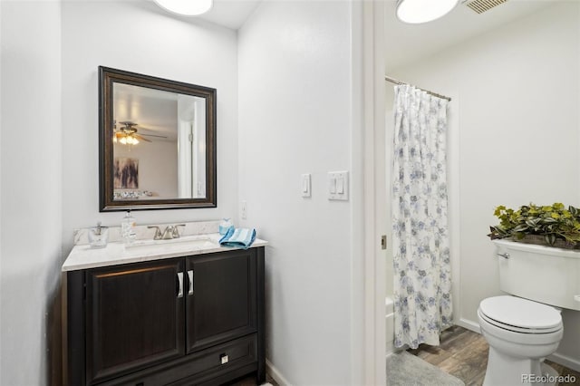 bathroom with baseboards, vanity, toilet, and wood finished floors