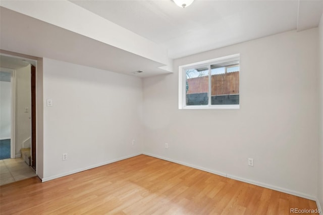 spare room with wood finished floors and baseboards