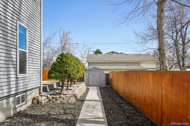 view of yard featuring a shed, an outdoor structure, and a fenced backyard