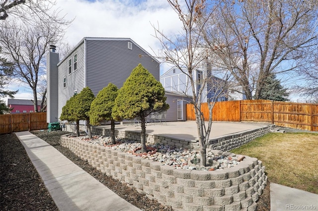 view of home's exterior with a patio area and fence