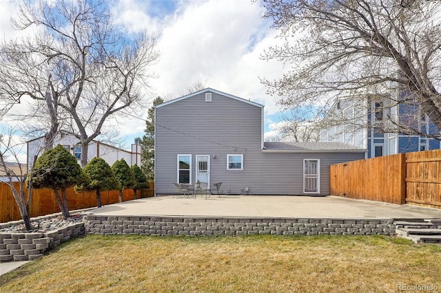 back of property with a yard, a patio area, and a fenced backyard