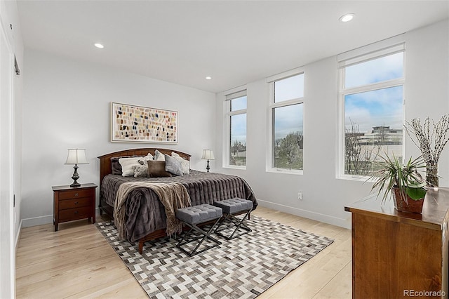 bedroom with recessed lighting, light wood finished floors, multiple windows, and baseboards